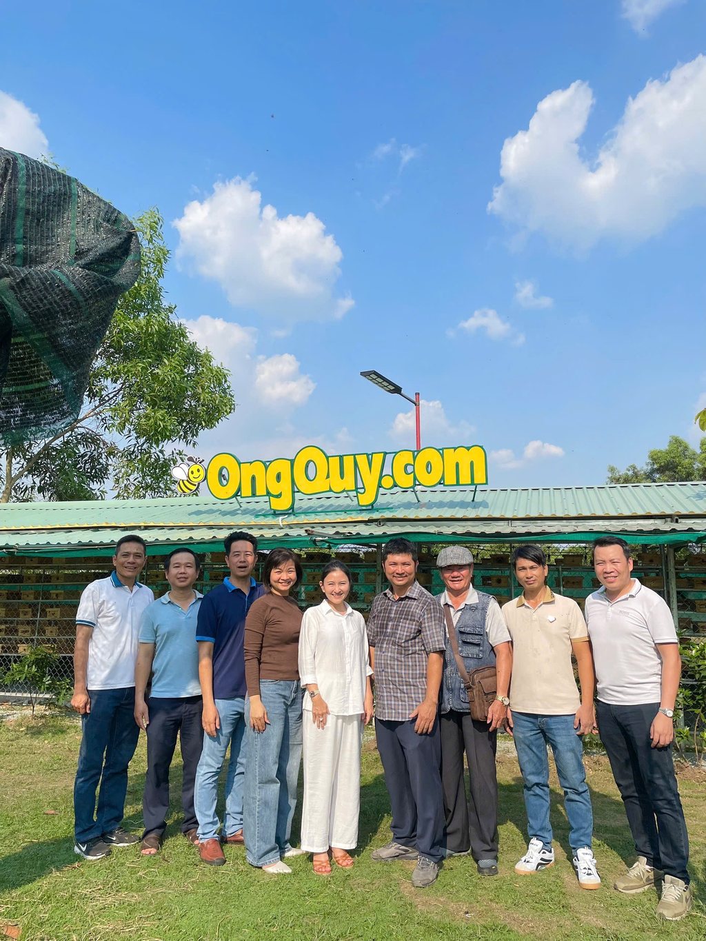 Trại ong dú OngQuý.com — biển hiệu vàng đặc trưng và đoàn khách tham quan